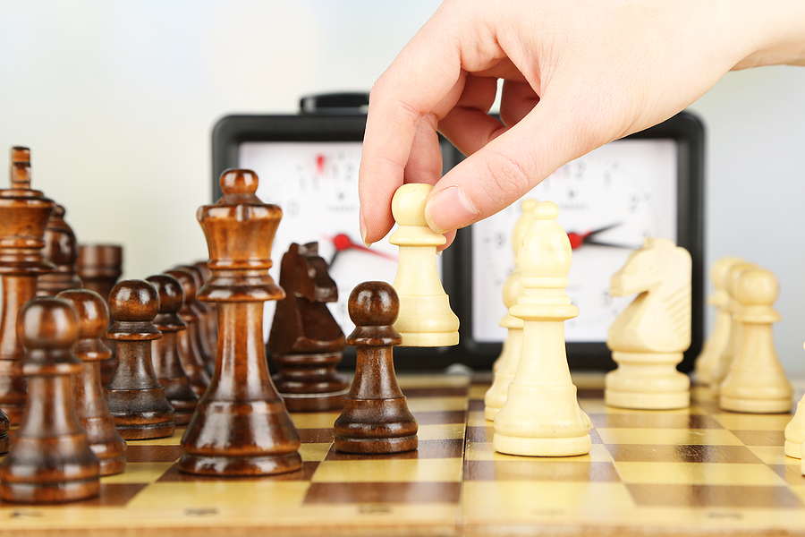 woman playing chess close up with chess clock